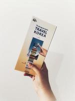 Jakarta, Indonesia in May 2022. A hand is holding a welcome guide book for travelers on vacation on Korea photo