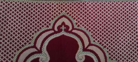 Prayer mat background. red carpet texture with abstract pattern photo