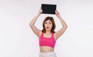 Portrait of excited young woman holding tablet mock up isolated over white background photo