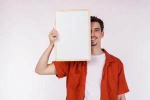 retrato de un hombre feliz que muestra un cartel en blanco sobre un fondo blanco aislado foto