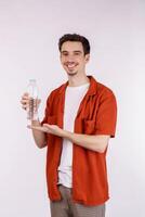 Portrait of Happy young man showing water in a bottle isolated over white background. photo