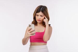 Retrato de mujer joven confundida a través de teléfono móvil aislado sobre fondo blanco. foto