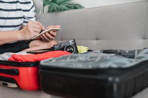 Asian man is preparing clothes in suitcases photo