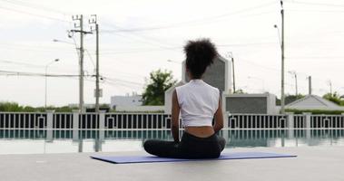 Yoga is done by African women at swimming pool background video