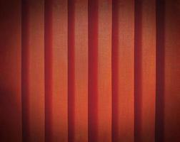 Close up pattern line of orange or red plastic curtain with vignette tone for background. Abstract, wall or wallpaper concept photo