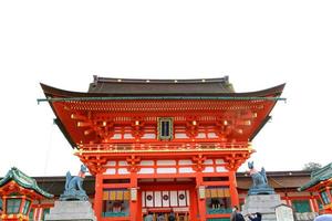 tokio, japón-18 de enero de 2023 santuario fushimi inari taisha y estatua de perro frente a la entrada o acceso con fondo de cielo. antiguo castillo o templo japonés. lugar sagrado de los japoneses. edificio. foto