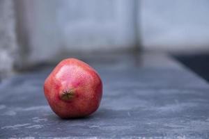 Ripe pomegranate on a stone table. Selective focus. photo
