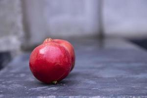 Ripe red pomegranate fruit on a dark background. photo