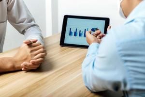 cropped view group of business people discussing financial graph chart on mobile tablet together in meeting room, online marketing, business finance meeting, investment, digital technology concept photo