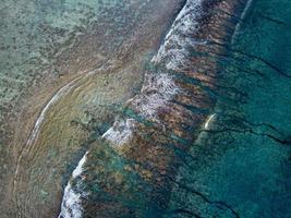 vista aérea de las olas en el arrecife de las islas cook de polinesia foto