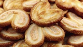 Rotating close up of fresh palm puff pastry in the shape of a heart. French biscuits with elephant ears. Close-up. video