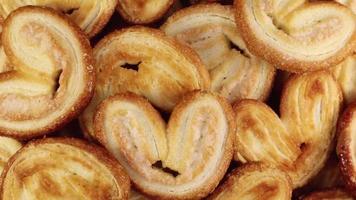 Rotating close up of fresh palm puff pastry in the shape of a heart. French biscuits with elephant ears. Close-up. video