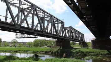 Eisenbahnbrücke über den Fluss, Ansicht von unten im Sommer. video