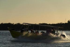 motor boat silhouette at sunset in ocean photo