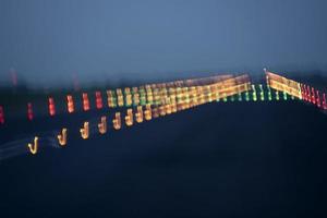 luces del aeropuerto en movimiento mientras despega por la noche foto