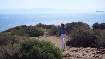 bellissimo ragazza passeggiate su il montagna prospiciente il mare video