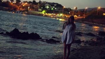 notte scena con bellezza giovane ragazza su il riva del mare video