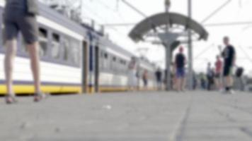 quai de la gare, les passagers attendent un train à grande vitesse. les passagers attendent de monter à bord du train à la gare. arrière-plan flou avec des personnes méconnaissables. video