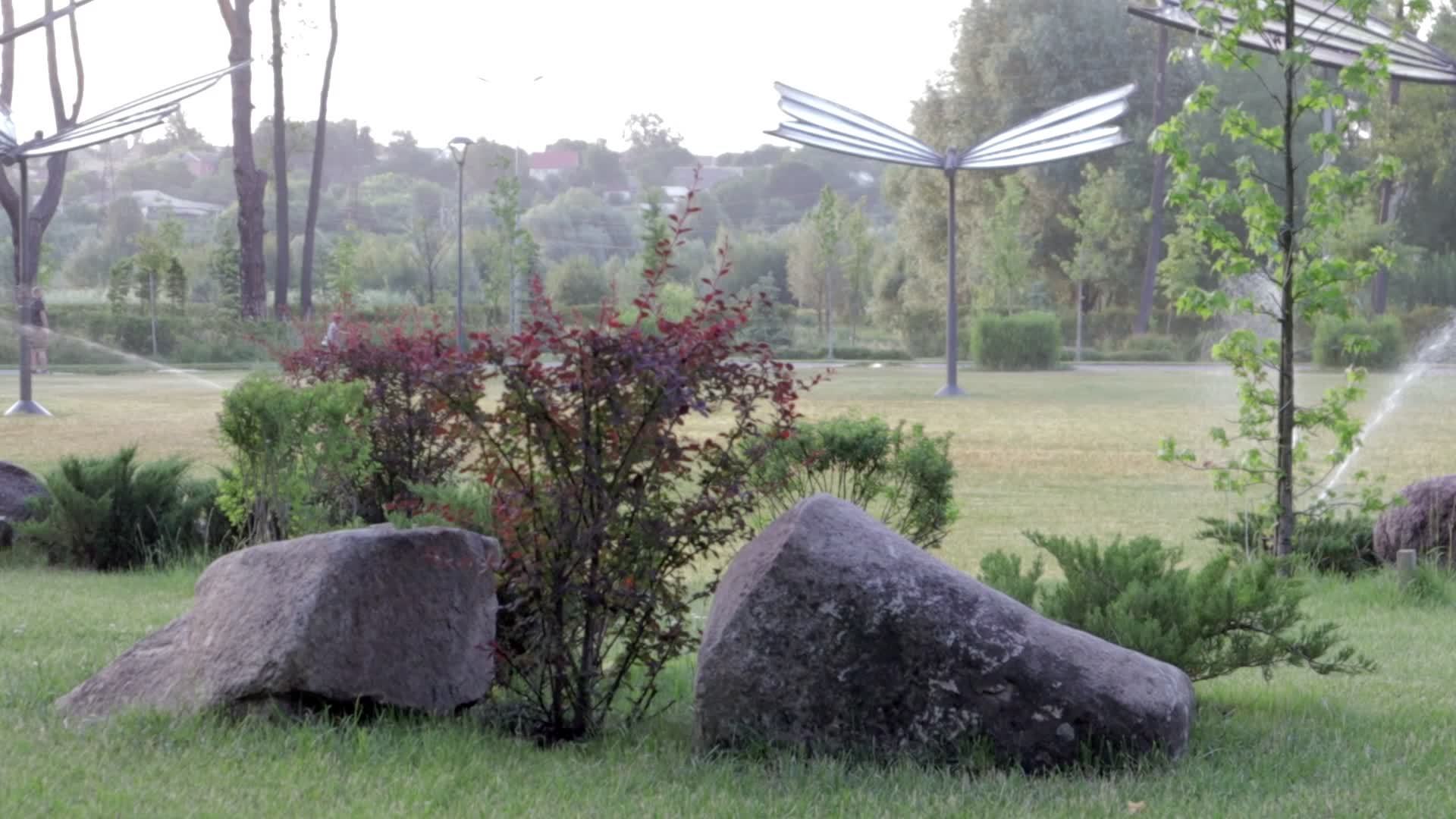 système d'irrigation de pelouse fonctionnant dans un parc verdoyant.  arroser la pelouse avec de l'eau par temps chaud. arroseur automatique. la  tête d'arrosage automatique arrosant la pelouse. jardin intelligent.  4539280 Photo de