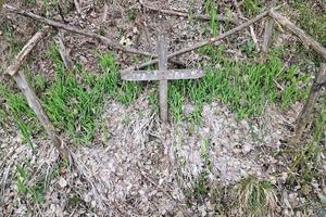 cruz de madera de tumba antigua en un campo foto
