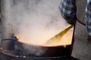 RANGO, ITALY - DECEMBER 8, 2017 - People cooking polenta traditional corn wheat meal photo