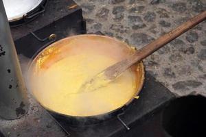 RANGO, ITALY - DECEMBER 8, 2017 - People cooking polenta traditional corn wheat meal photo