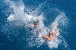 people jumping in water in maldives photo