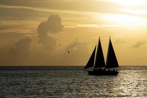 hermosa puesta de sol con silueta de velero foto