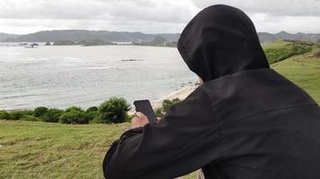 relax on a hill with a stretch of green meadows with views of white sand beaches video