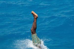 hombre maldivo buceando desde un barco foto