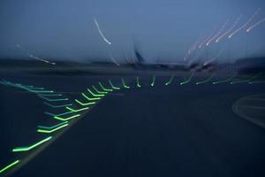 luces del aeropuerto en movimiento mientras despega por la noche foto