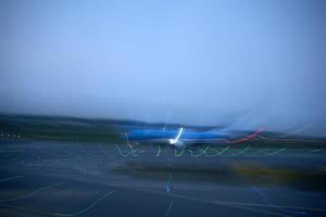 luces del aeropuerto en movimiento mientras el avión despega por la noche foto