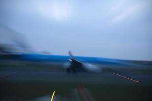 luces del aeropuerto en movimiento mientras el avión despega por la noche foto