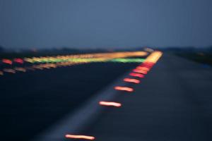 luces del aeropuerto en movimiento mientras despega por la noche foto