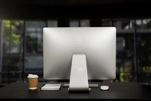 workspace with computer, laptop, office supplies, and coffee cup, smartphone, and tablet at office. desk work concept. photo