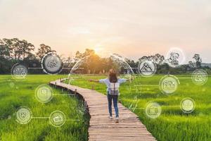 Young woman travelers looking at the beautiful green paddy field while traveling on vacation with travel icons diagram concept photo