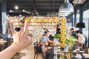 Young woman traveler using smartphone to give a five-star satisfaction rating of the food and drinks at restaurant on social media, Travel lifestyle concept photo