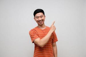 Positive asian man striped shirt happiness smile gesture point finger isolated photo