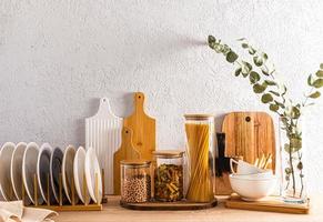 hermoso fondo de cocina. un conjunto de utensilios de cocina ecológicos en una encimera de madera en un interior de cocina moderno. vista frontal.