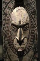 papua wood mask statue photo