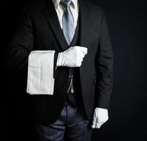 retrato de mayordomo o camarero con traje oscuro parado en elegante atención. concepto de industria de servicios y cortesía inmaculada. foto