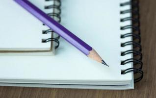 Close up pencil and spiral notebook on wood table, Selective focus point photo