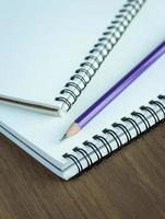 Close up pencil and spiral notebook on wood table, Selective focus point photo