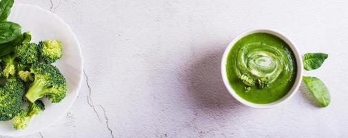 Bowl with broccoli cream soup on the table. Healthy food. Top  view. Web banner photo