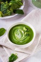 Bowl with broccoli cream soup on the table. Healthy food. Vertical view photo