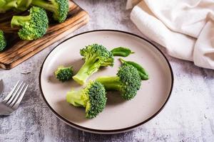 hojas frescas de brócoli y espinacas en un plato sobre la mesa. comida sana, comida verde.