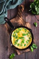 tortilla rellena de espinacas en una sartén para el desayuno. comida hecha en casa. vista superior y vertical foto