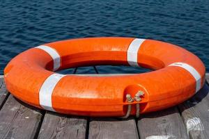 The lifebuoy is lying on a wooden pier. The concept of saving drowning photo