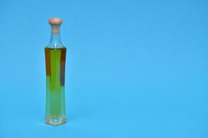 aceite virgen extra en la botella aislado sobre fondo azul. foto