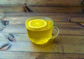 Green tea with lemon in a glass mug. photo